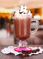 Layered coffee in glass on table on bright background