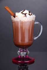 Layered coffee in glass on table on grey background