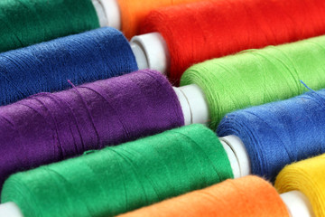 Many-coloured bobbins of thread closeup
