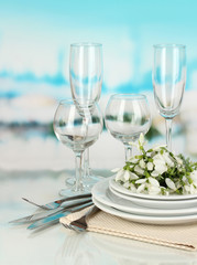 Serving dishes and snowdrops on blue natural background