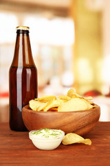 Potato chips and glass bottle with beverage,