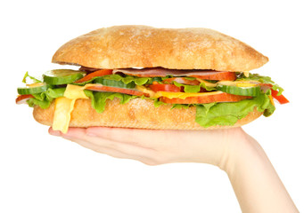 Fresh and tasty sandwich with ham and vegetables in hands