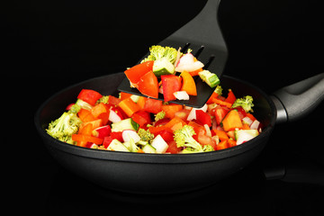 Vegetable ragout in pan, isolated on black