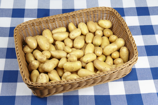 Korb mit mit Drillingen (Kartoffeln) auf karierter Tischdecke