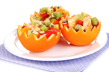 Fruit salad in hollowed-out orange isolated on white