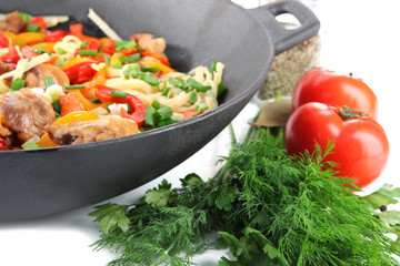 Noodles with vegetables on wok close-up