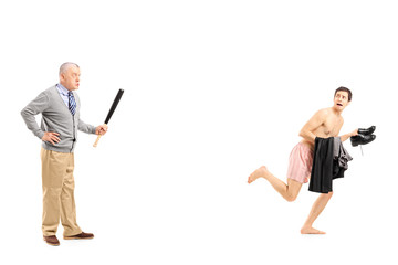 Middle aged man with baseball bat shouting at a young naked man