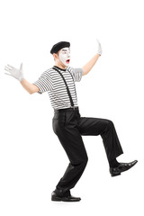 Full length portrait of a surpised mime artist gesturing with ha