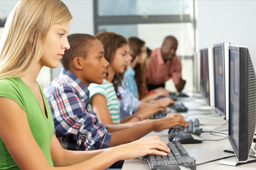Group Of Students Working At Computers In Classroom