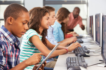 Boy Using Digital Tablet In Computer Class