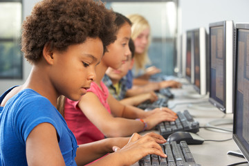 Elementary Students Working At Computers In Classroom