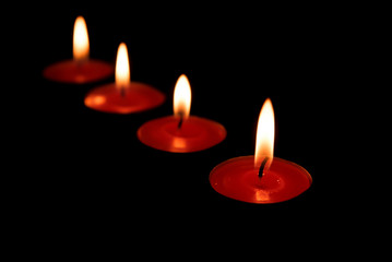 red candles burning in a dark space