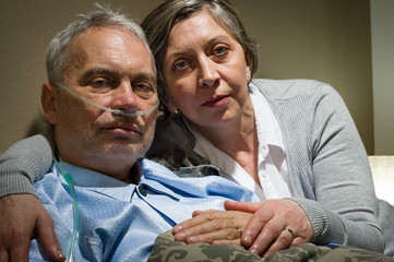 Anxious senior wife holding her sick husband