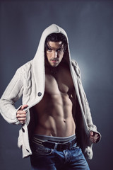 Fototapeta na wymiar Handsome fashion model posing with stomach muscles