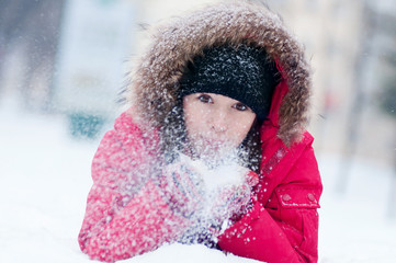 Happy young woman plays with a snow