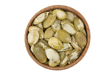 Shelled raw pumpkin seeds in wooden bowl isolated on white