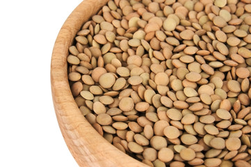 Raw lentils in wooden bowl close-up