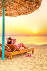 Relax under parasol on the beach of Red Sea at sunrise
