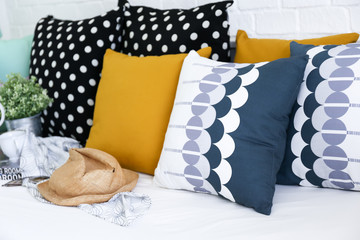 Colorful pillows on a sofa with white brick wall in background