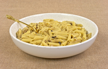 Cooked penne pasta with mushrooms in bowl