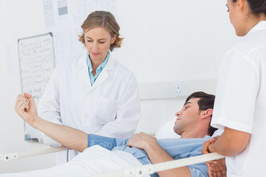Doctors measuring the blood pressure of a male patient