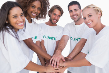 Smiling volunteer group putting hands together