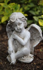 Fototapeta na wymiar Ein Engel sitzt auf einem Grab