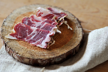 Slices of cured jamon on a wooden cutting board