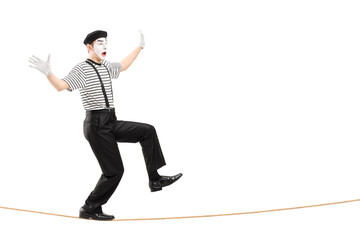 Full length portrait of an excited male mime artist walking on a