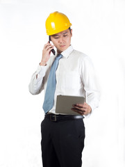construction supervisor checking on tablet and talking on phone