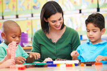 Elementary Pupils Counting With Teacher In Classroom