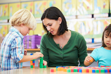 Elementary Pupils Counting With Teacher In Classroom
