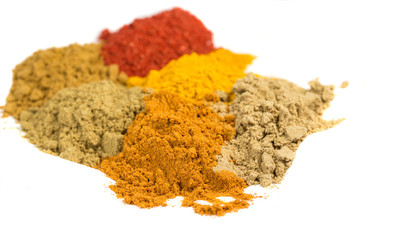 Various powdered spices over white background