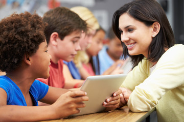 Pupils In Class Using Digital Tablet With Teacher