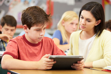 Fototapeta na wymiar Pupils In Class Using Digital Tablet With Teacher