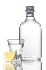 Bottle of vodka and wineglass with lemon isolated on white