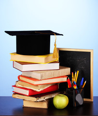 Books and magister cap against school board