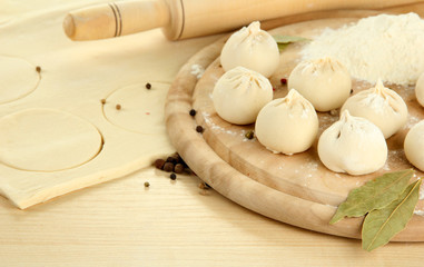Raw dumplings and dough, on wooden table