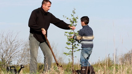 Father and son planting a tree.