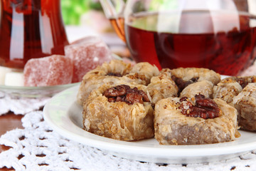 Sweet baklava on plate with tea on table close-up