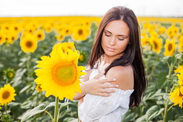 Beautiful young woman on the sunflowers field