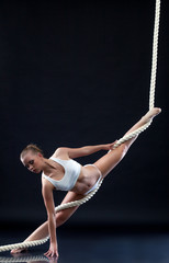 Athletic aerialist posing with rope