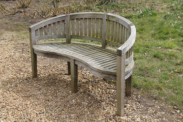 A Wooden Garden Bench with a Round Back.