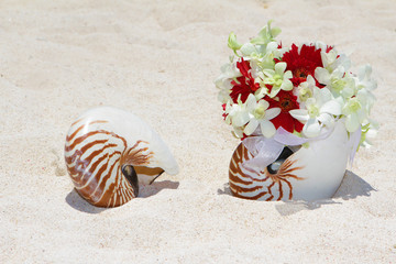 bridal bouquet with wedding rings in a shell on sand tropical be