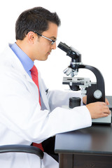 A close-up portrait of a doctor looking through a microscope