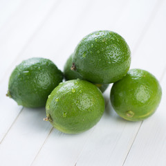 Ripe limes covered with water drops, close-up, studio shot