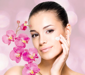 woman applying cosmetic cream  on face