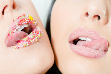 Naklejka premium Closeup on two female sweet candy lips with licking tongue