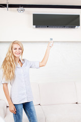 Fototapeta na wymiar Female holding a remote control air conditioner