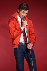 Retro fifties singer wearing red jacket with jeans and tie. Vint